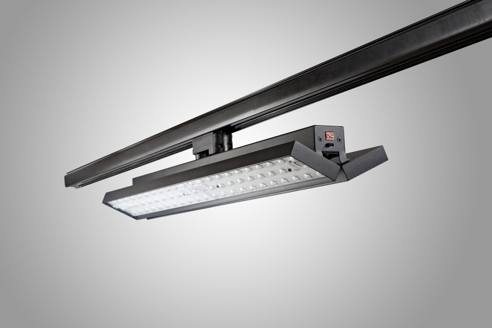 Angled side view showing an independently tilted panel on a linear track fixture