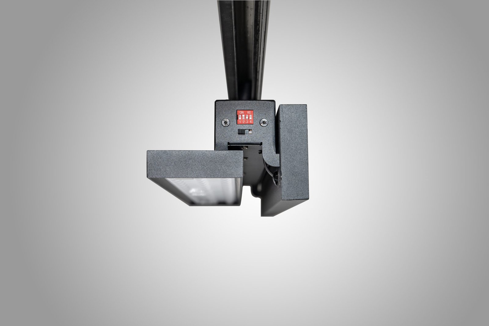 Adjustable dual-panel track light with one panel rotated steeply for aiming demonstration